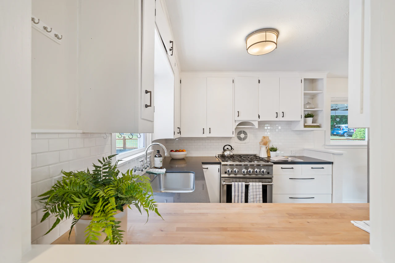 Encimera de madera butcher block en una cocina blanca y luminosa