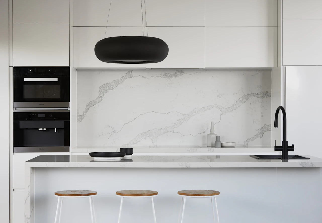 Cocina blanca con encimera y salpicadero blancos de vetas suaves