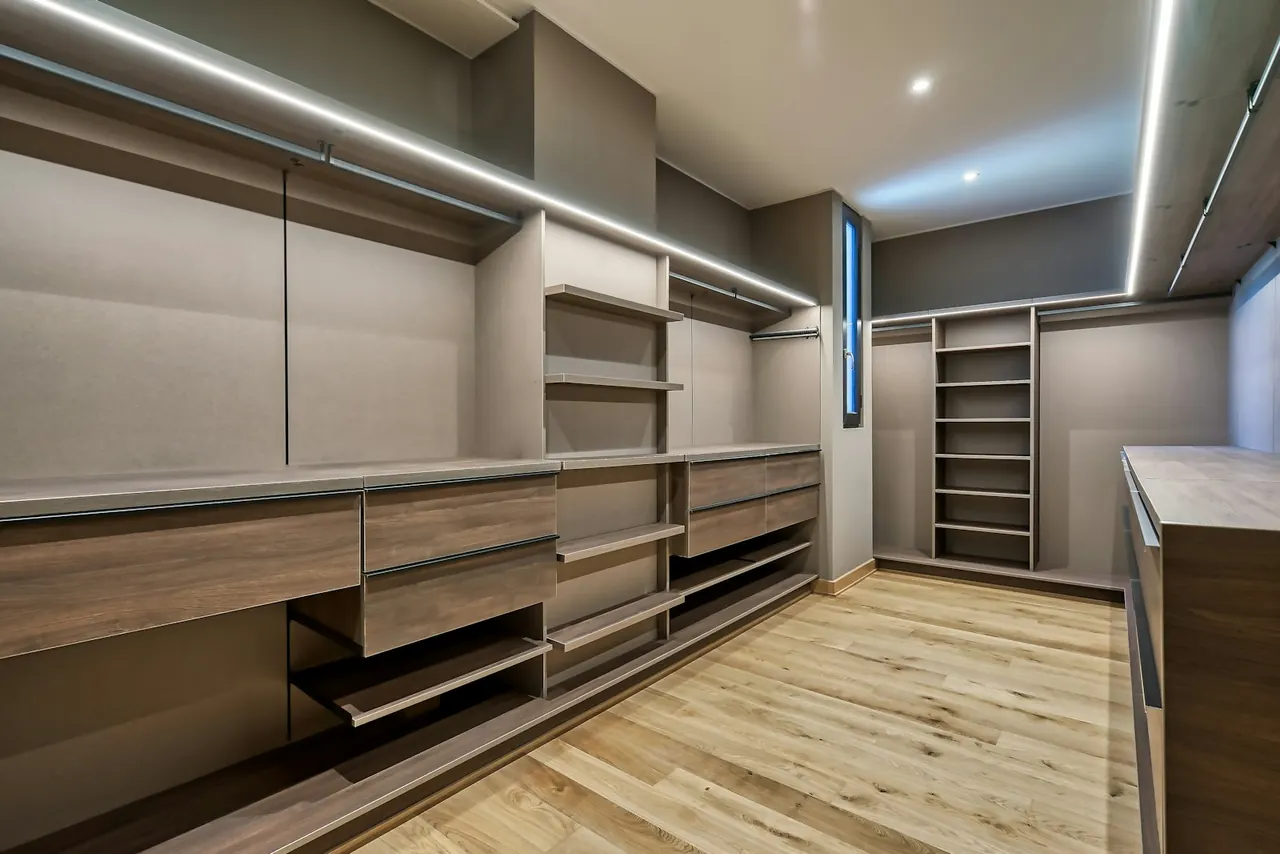 Long walk-in closet with drawers and LED lighting