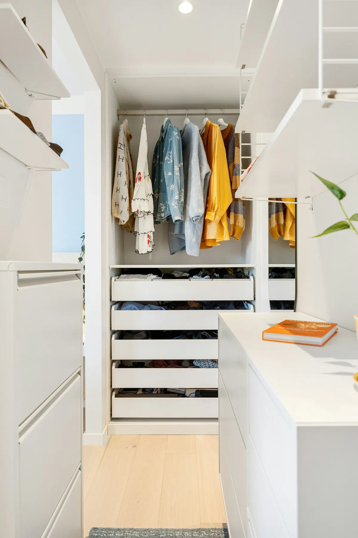 White walk-in closet with drawers and an island