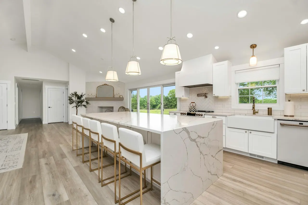 Large kitchen island with a veined waterfall countertop