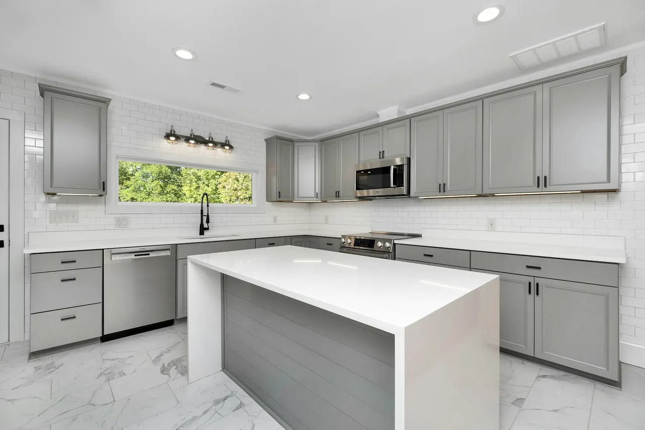 Grey kitchen with a white waterfall island