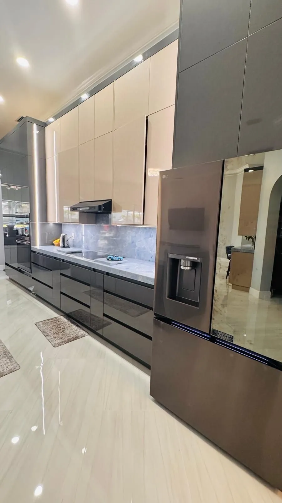 Gabinetes brillantes gris y crema de altura completa con salpicadero de piedra azul